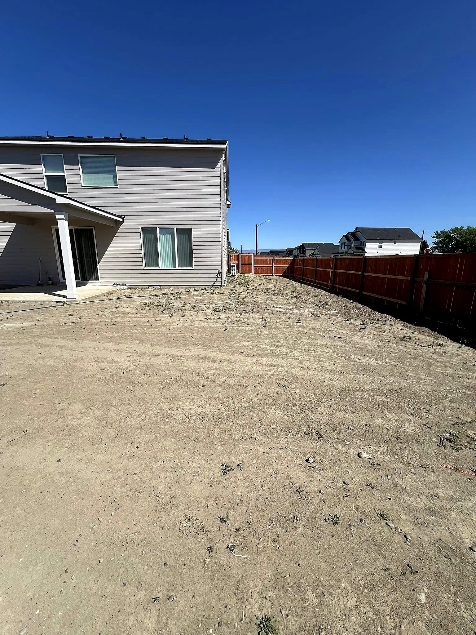 Before: a bare dirt backyard graded and waiting for a new lawn
