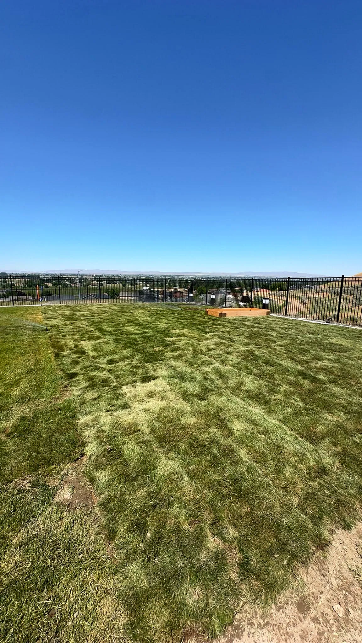 A sloped property lawn re-established and maintained with valley views in the distance